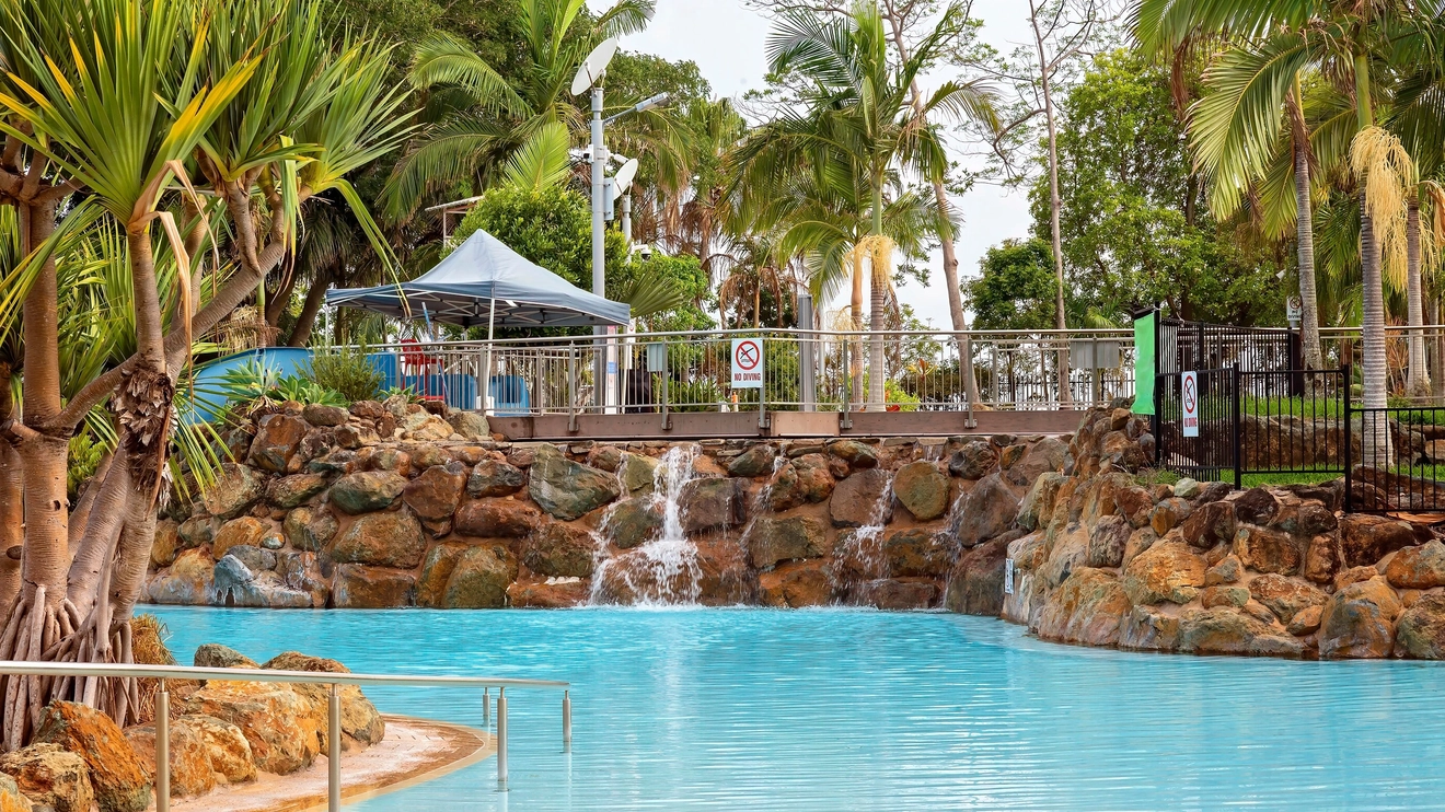 A palm-tree lined swimming pool at Bluewater Lagoon, Mackay. Image credit: Jackson Stock Photography/Shutterstock.com
