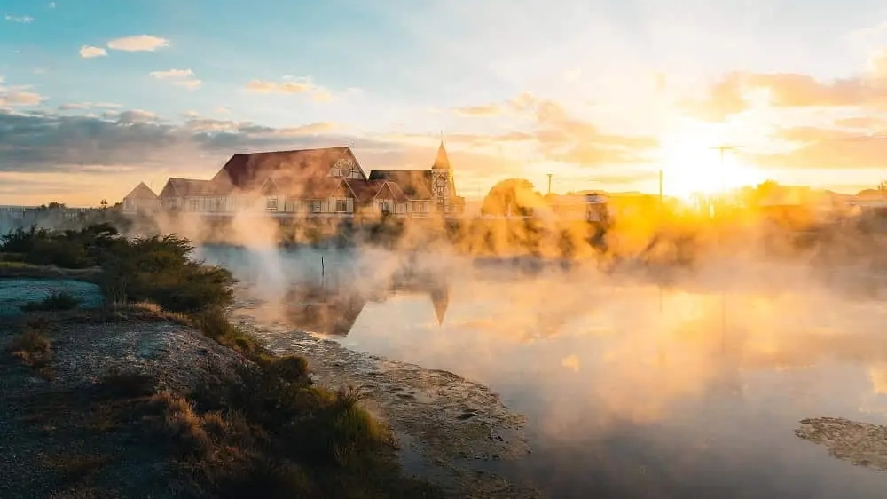 Steam rising from thermal springs, buildings in the background, in Ohinemutu Village, Rotorua.