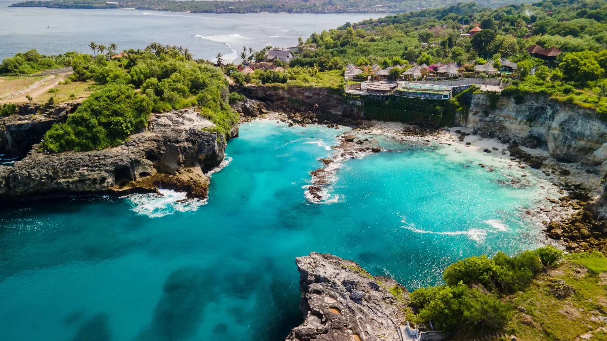 Aerial view of cliffs at Nusa Lembongan, Bali, enclosing a cove of turquoise water. Image credit: stock.adobe.com