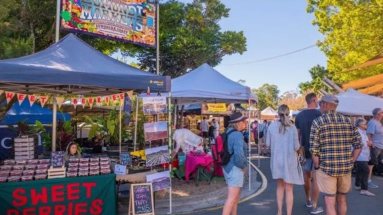 People walking among stalls at the Eumundi Markets, Sunshine Coast. Image credit: Tourism and Events Queensland