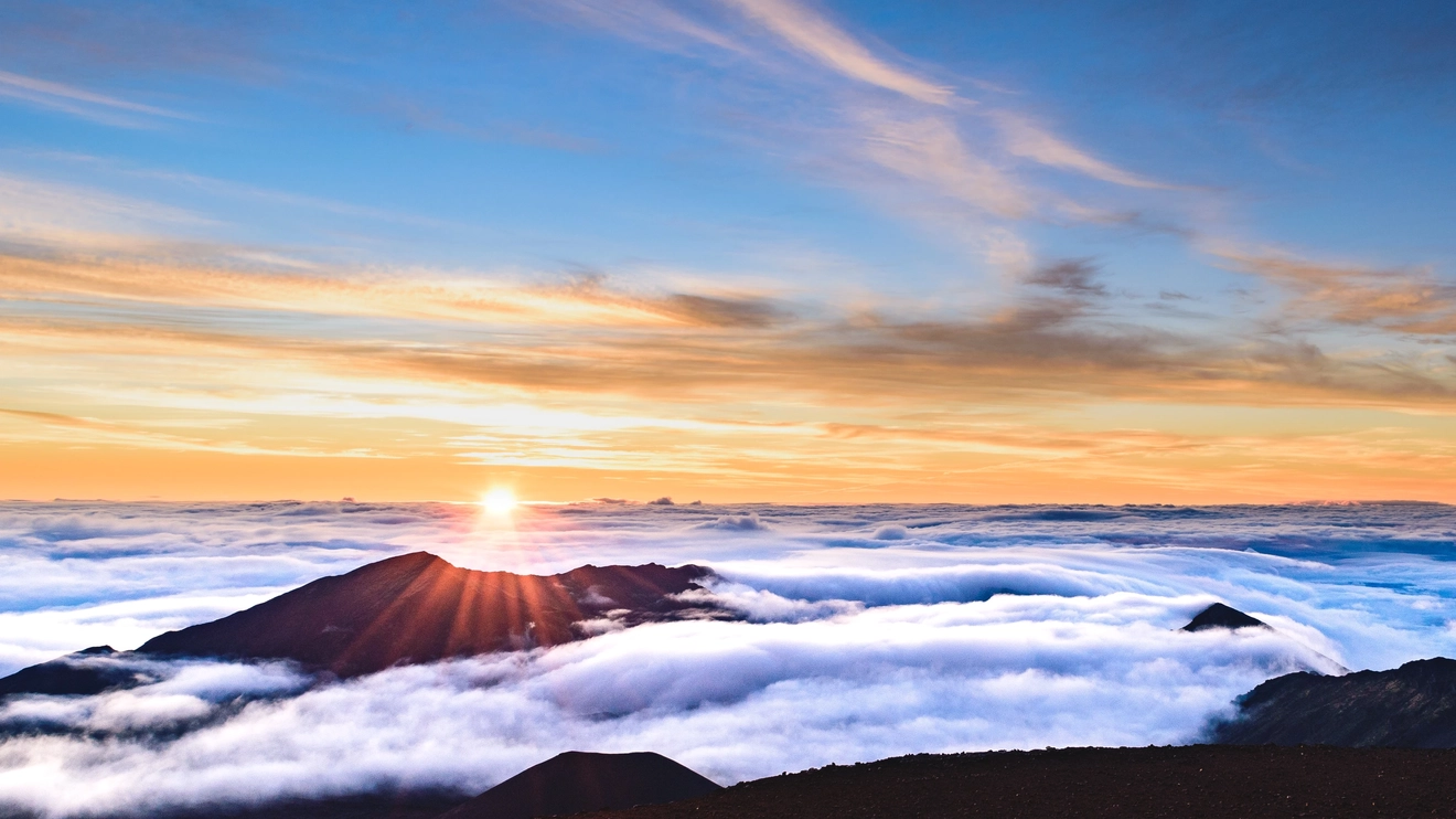 Golden glowing clouds at sunrise at Mount Haleakala in Hawaii