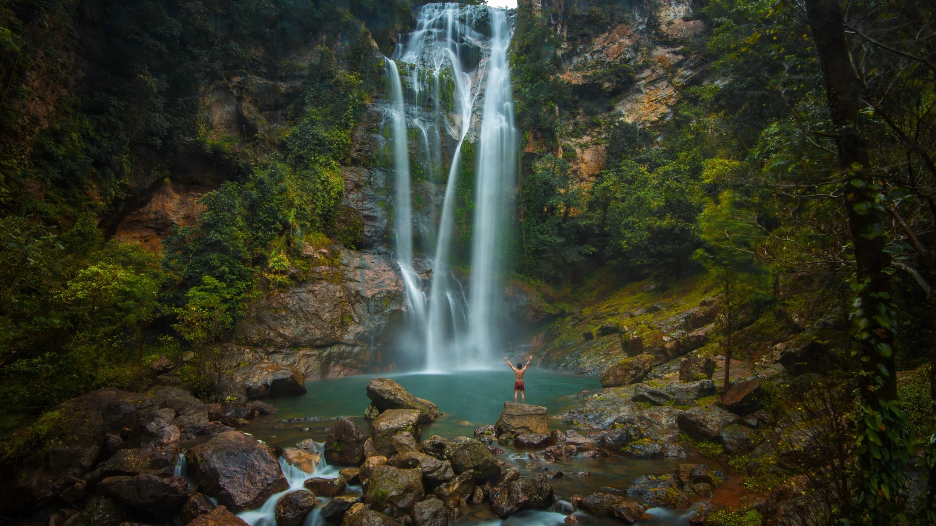 Tourist stands at the edge of the beautiful swimming hole at the base of Cunca Rami, Labuan Bajo. Image credit: stock.adobe.com