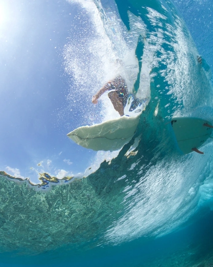 View from underwater of a surfer riding a wave