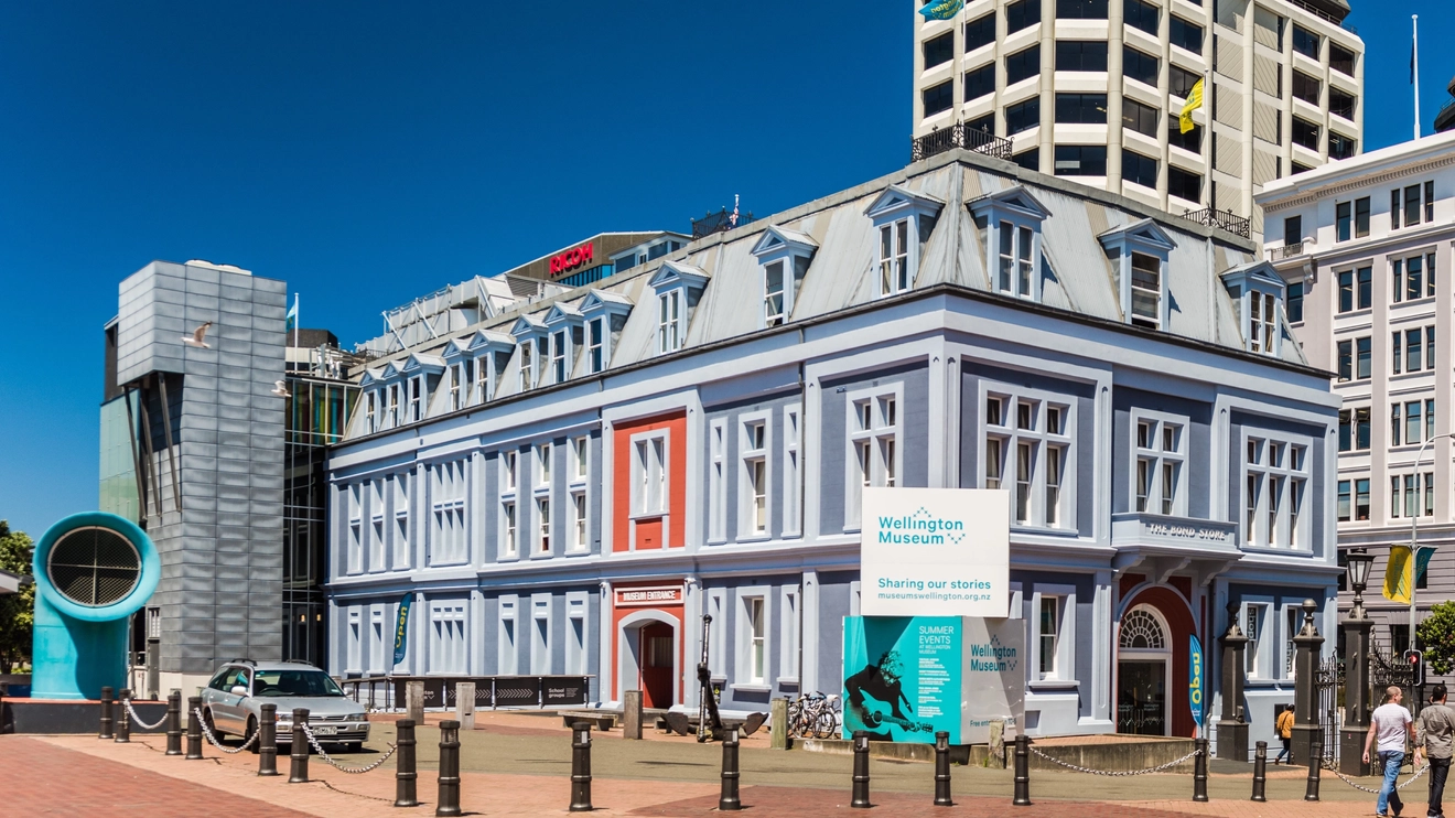 People walking outside the blue Wellington Museum on a sunny day, Wellington, New Zealand. Image credit: WellingtonNZ