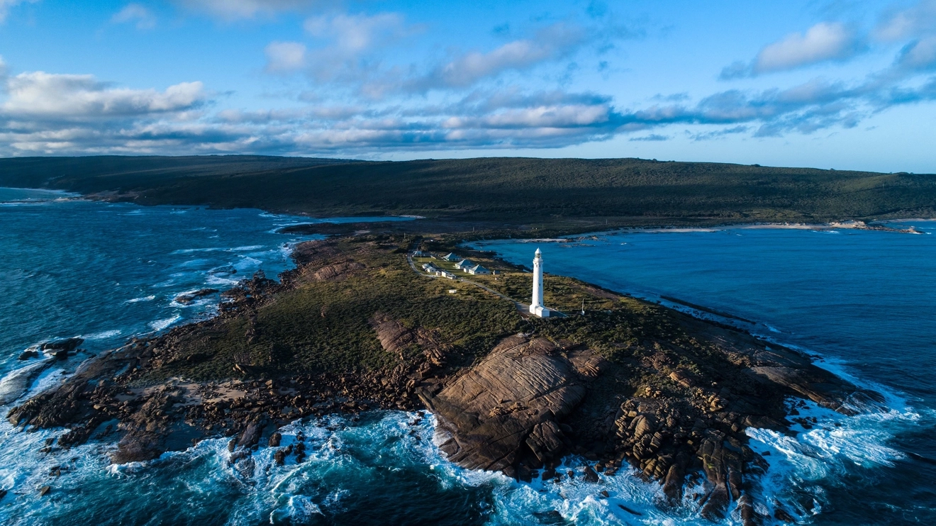 Aerial view of Cape Leeuwin Lighthouse, Augusta, with wild water all around it. Image credit: Tourism Western Australia