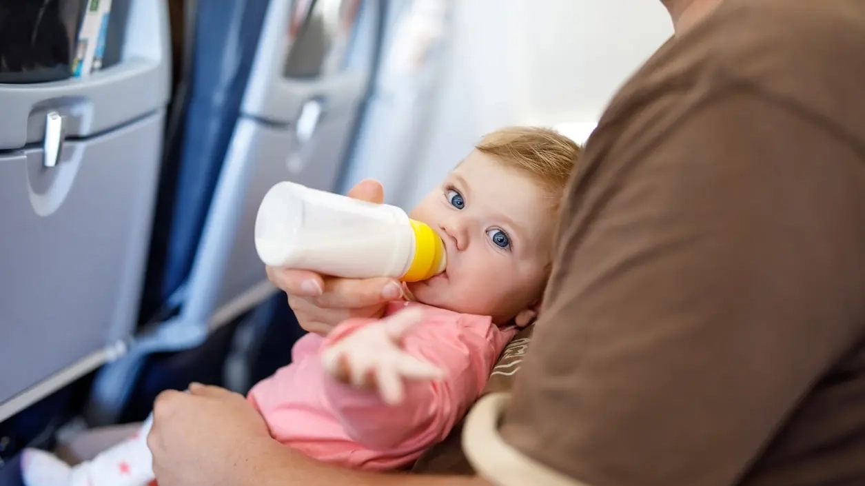 A Dad feeding his baby infant in a bottle. Image credit: iStock