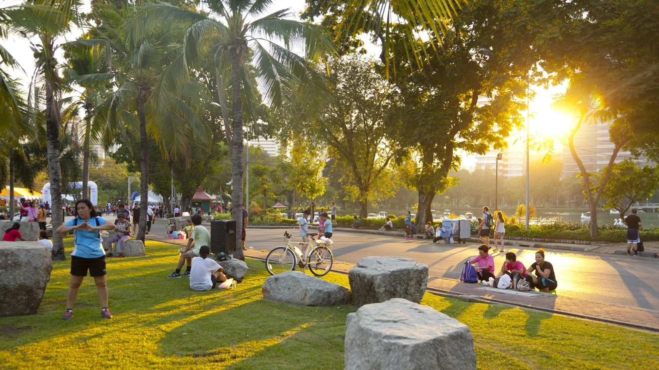 Bangkok locals enjoying the grass and greenery of Lumpini Park. Image credit: stock.adobe.com
