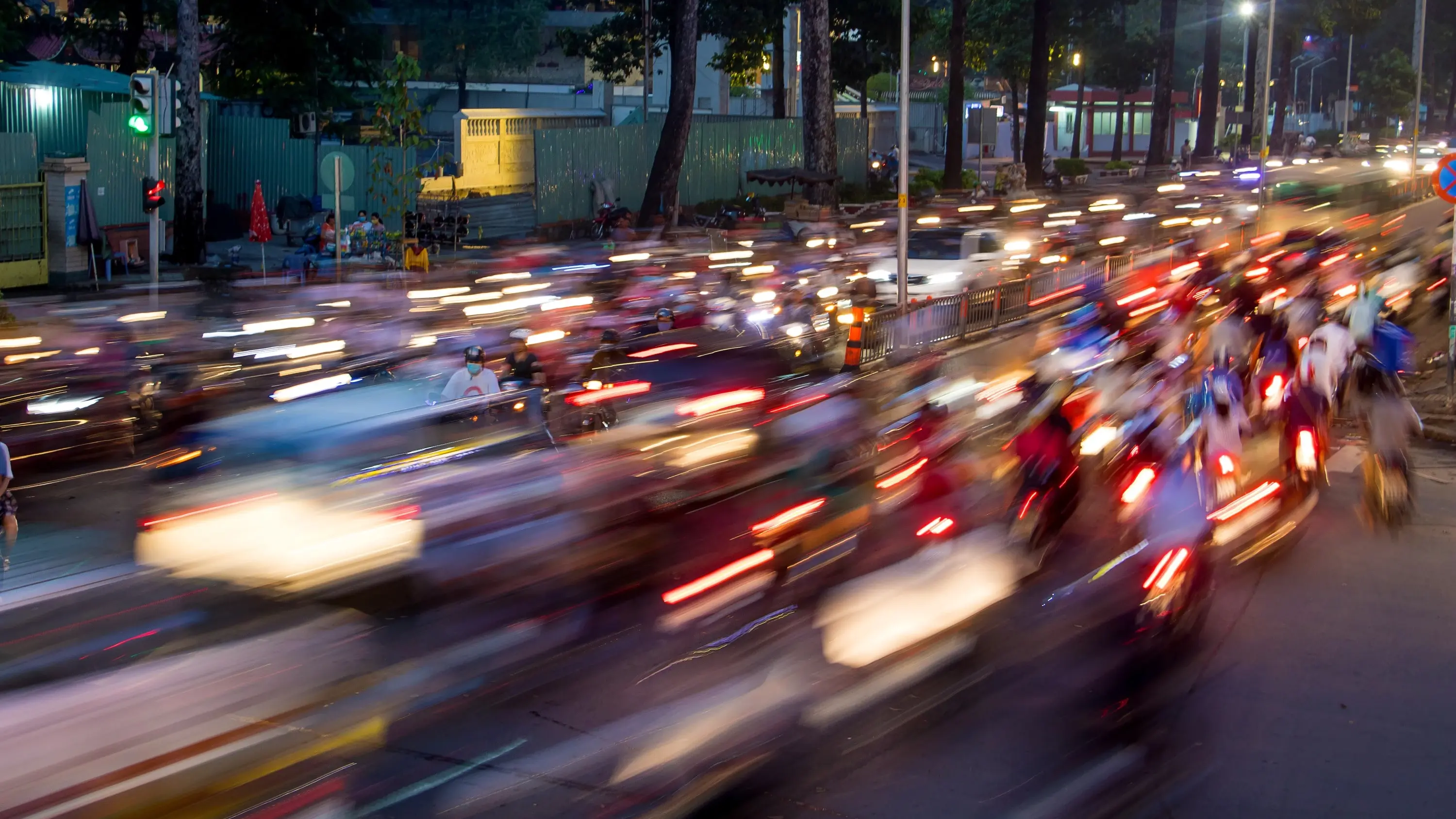 Dense traffic at an intersection in Ho Chi Minh City at night, with blurred lights passing through motorbikes and vehicles. Image credit: stock.adobe.com