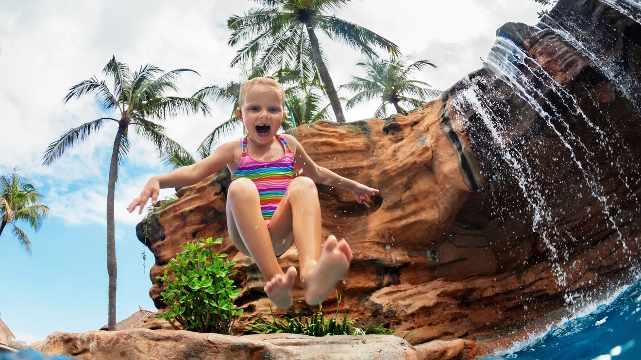Child jumping into water at Waterbom Park, Bali, Indonesia.