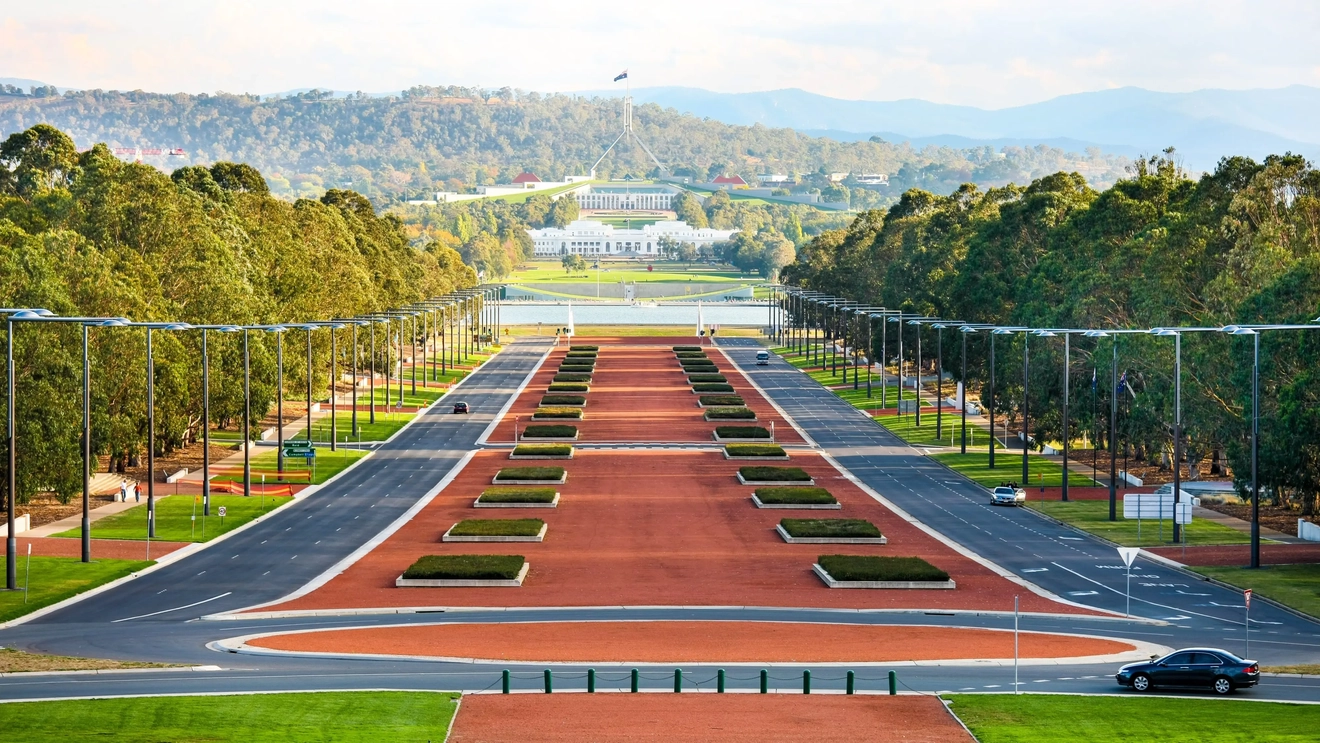 坎培拉國會大廈 (Parliament House) 在陽光普照日子的廣角視野，背景是叢林。圖像來源：stock.adobe.com