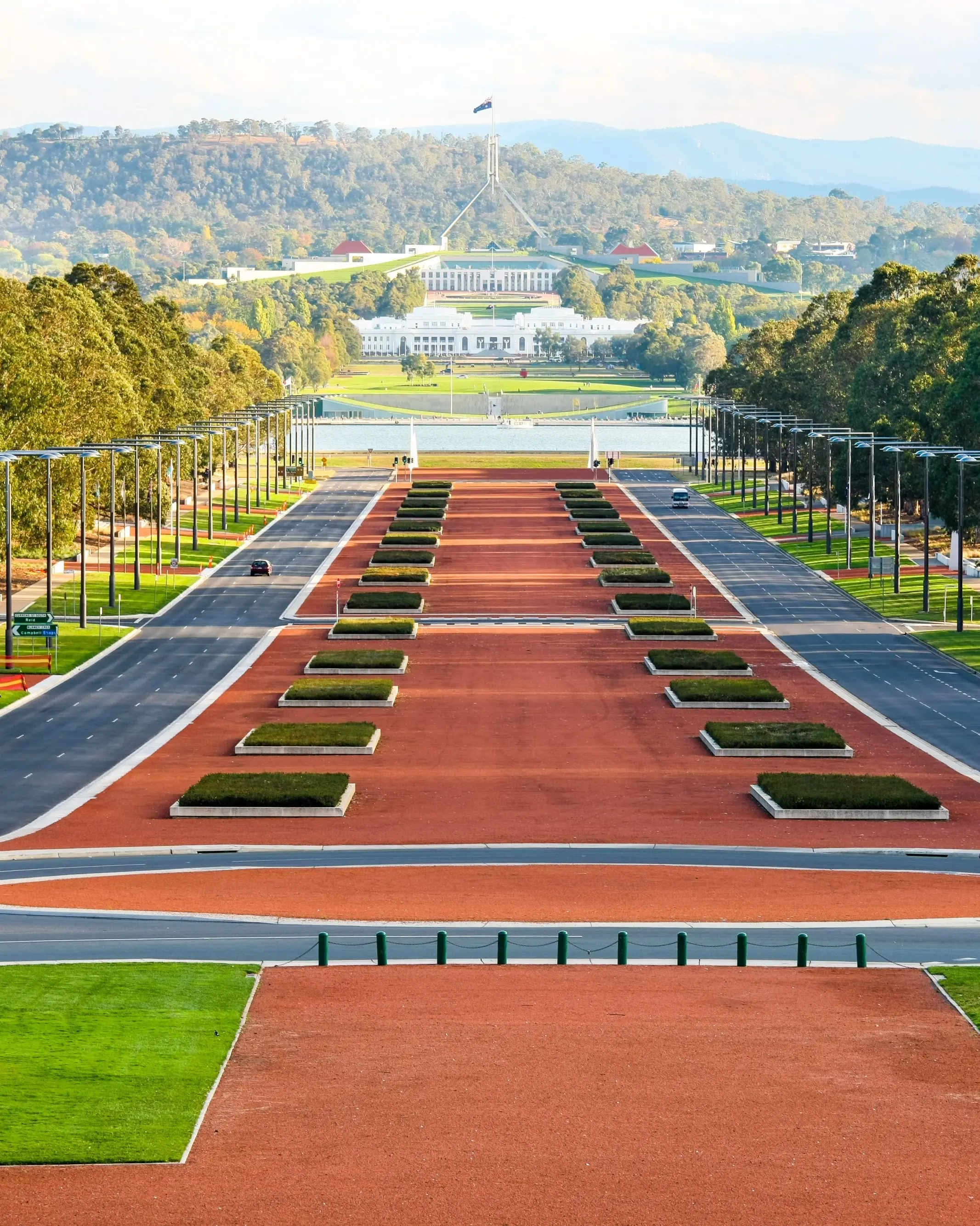 Wide-angle view of Parliament House with bushland in background on a sunny day, Canberra. Image credit: stock.adobe.com