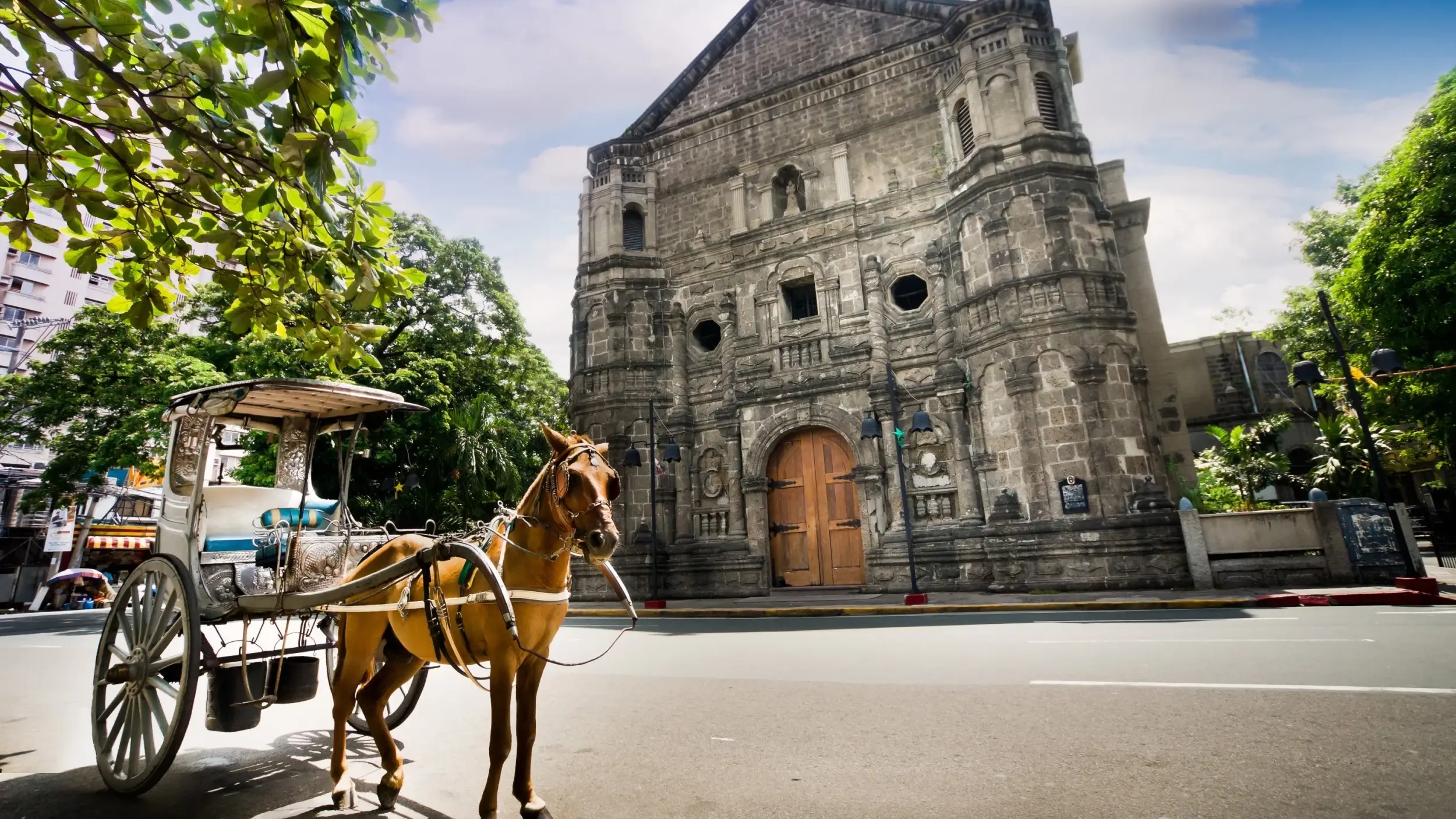 Traditional *kalesa* (horse-drawn carriage) in front of Malate church in Intramuros, Manila. Image credit: stock.adobe.com