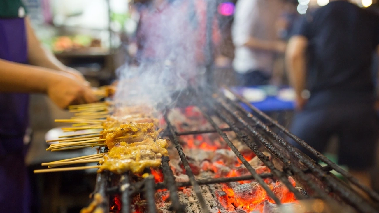 Grilling skewers of meat in Thailand.