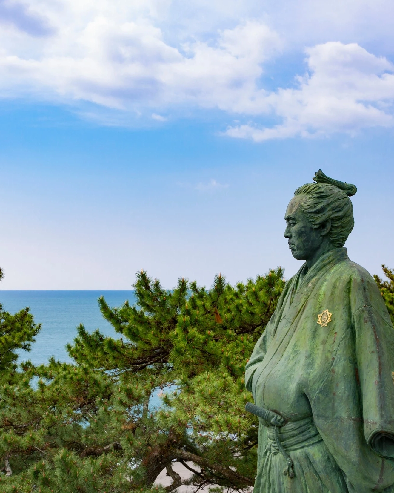 Statue of Ryoma Sakamoto at Katsurahama, with trees and ocean in background. Image credit: stock.adobe.com