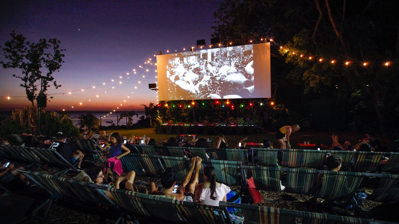 People at an outdoor movie screening at Deckchair Cinema at sunset. Image credit: Tourism NT/Friederike Franze
