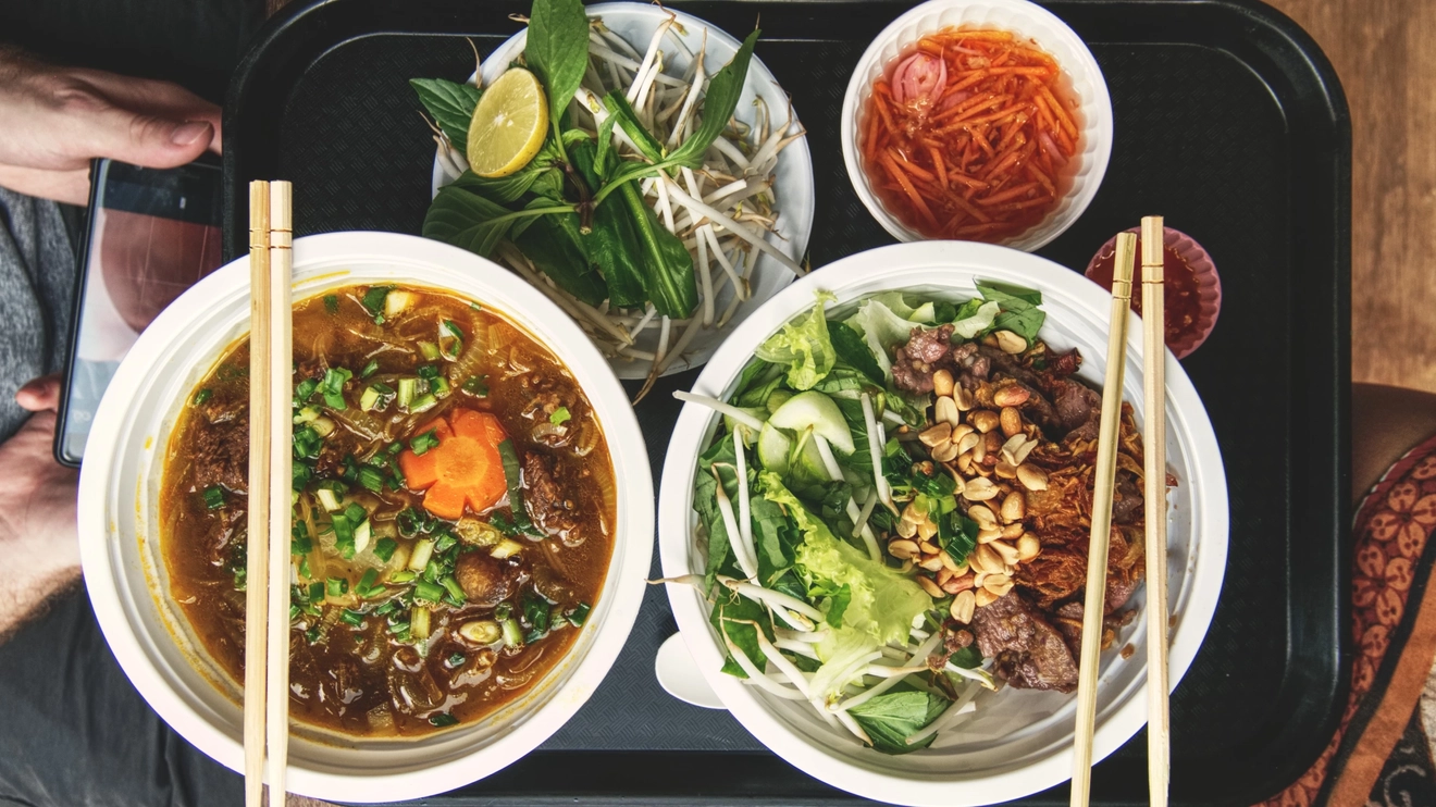 Top view of bowls of food on a tray at Ben Thanh street-food market in Ho Chi Minh City, Vietnam. Image credit: stock.adobe.com