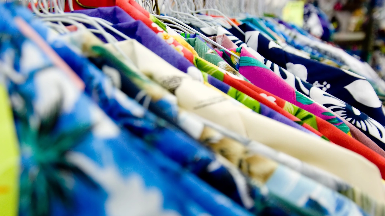 Close-up of a tightly packed rack of colourful Hawaiian shirts on hangers. Image credit: stock.adobe.com