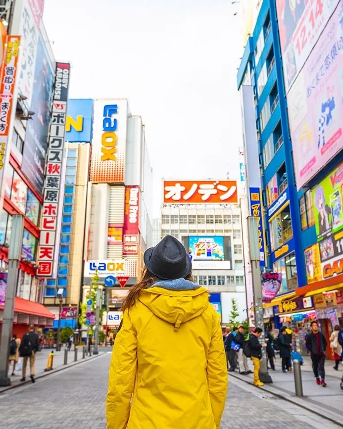 A woman stands in the street in Tokyo.