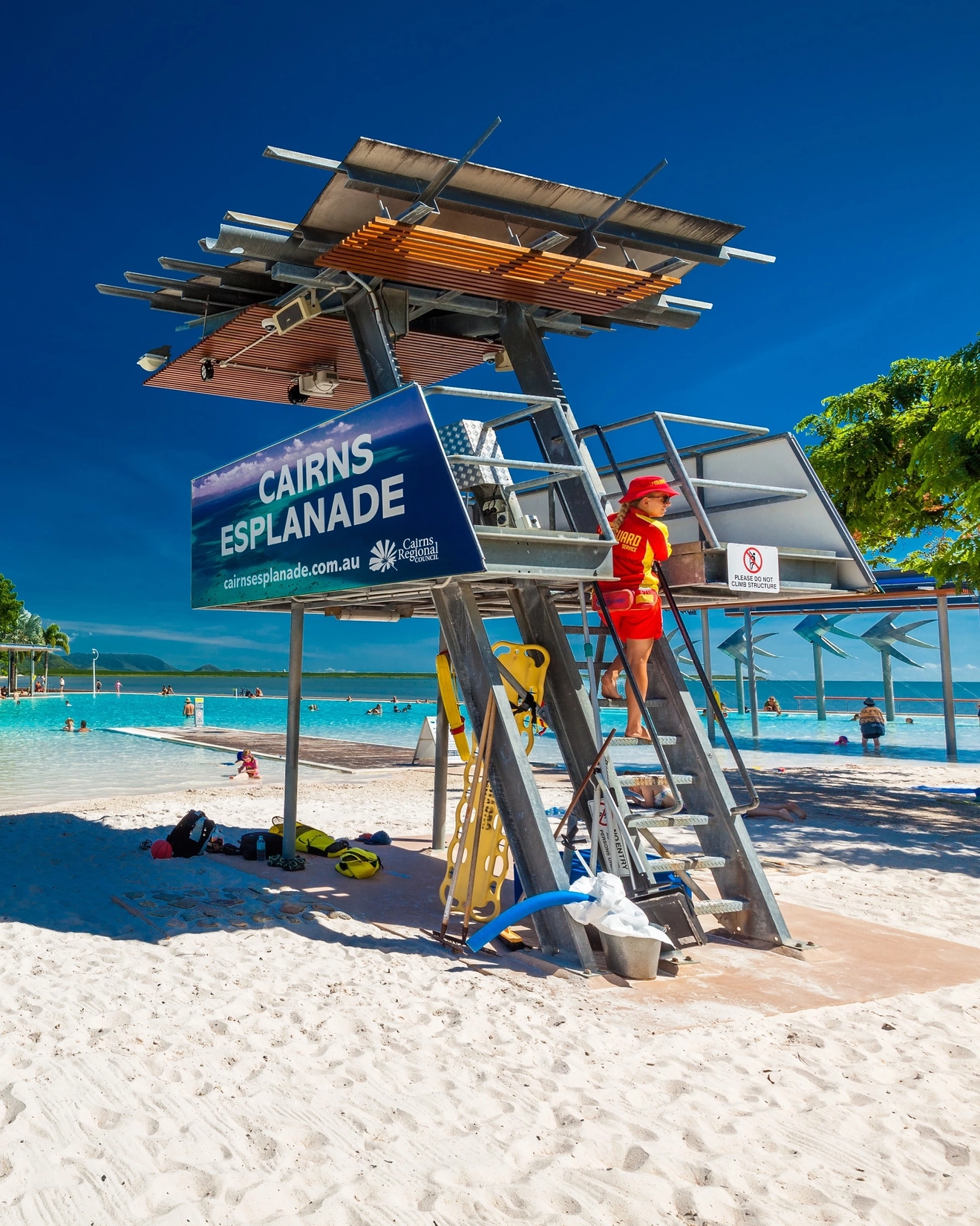 Lifesaver lookout on the artificial sand beach looking over the clear blue waters of Cairns Esplanade Lagoon. Image credit: Martin Valigursky/Shutterstock