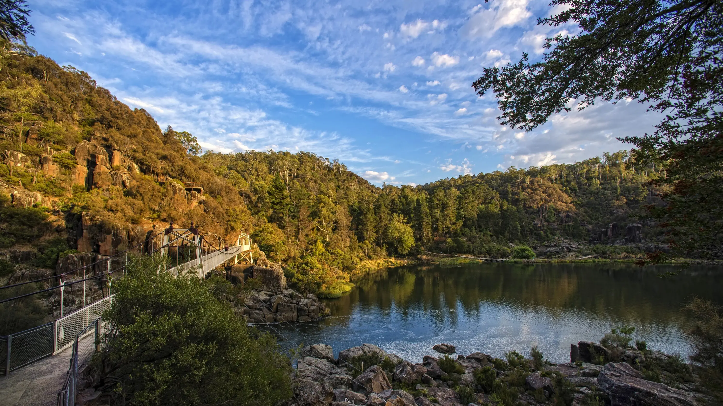 Cataract Gorge, with a lake surrounded by trees and a boardwalk on the left. Image credit: Tourism Tasmania/Rob Burnett