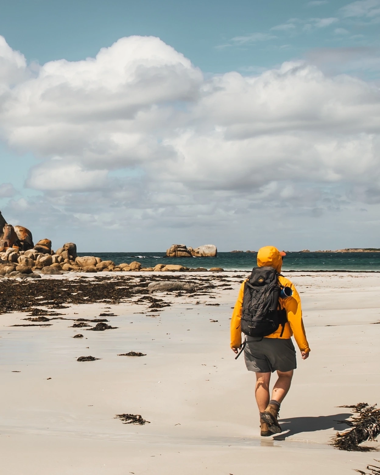 Hiker on rocky Tasmanian beach, wukalina Walk. You’ll see another side of Aboriginal Australia in Tasmania. Image credit: Tourism Tasmania/Tayla Gentle