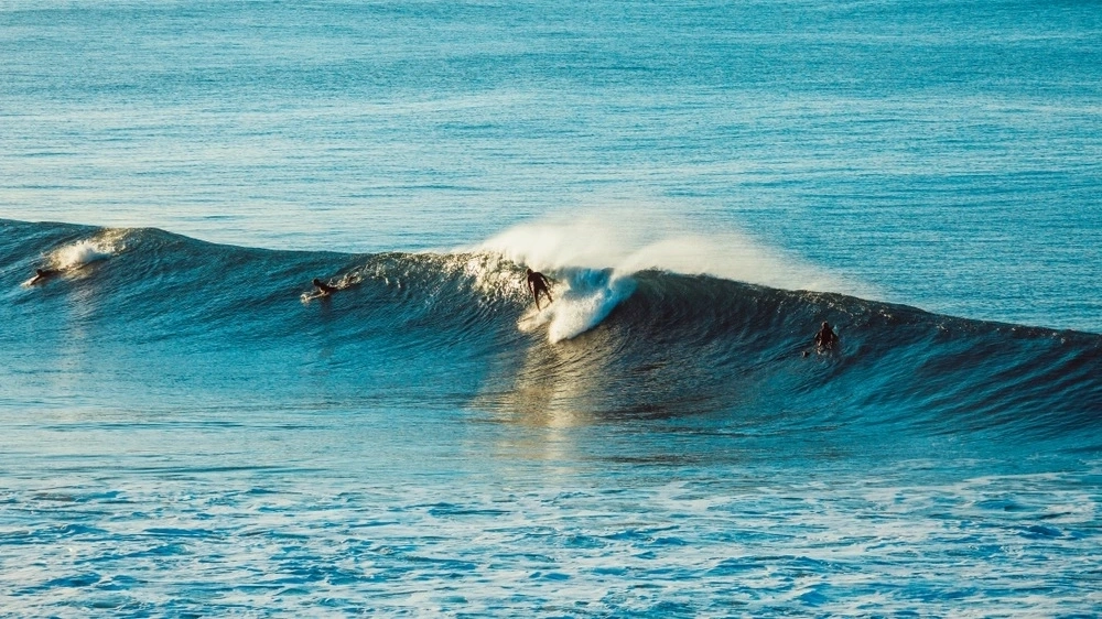 Surfers riding the waves at Bells Beach, one of the most famous surfing hotspots.