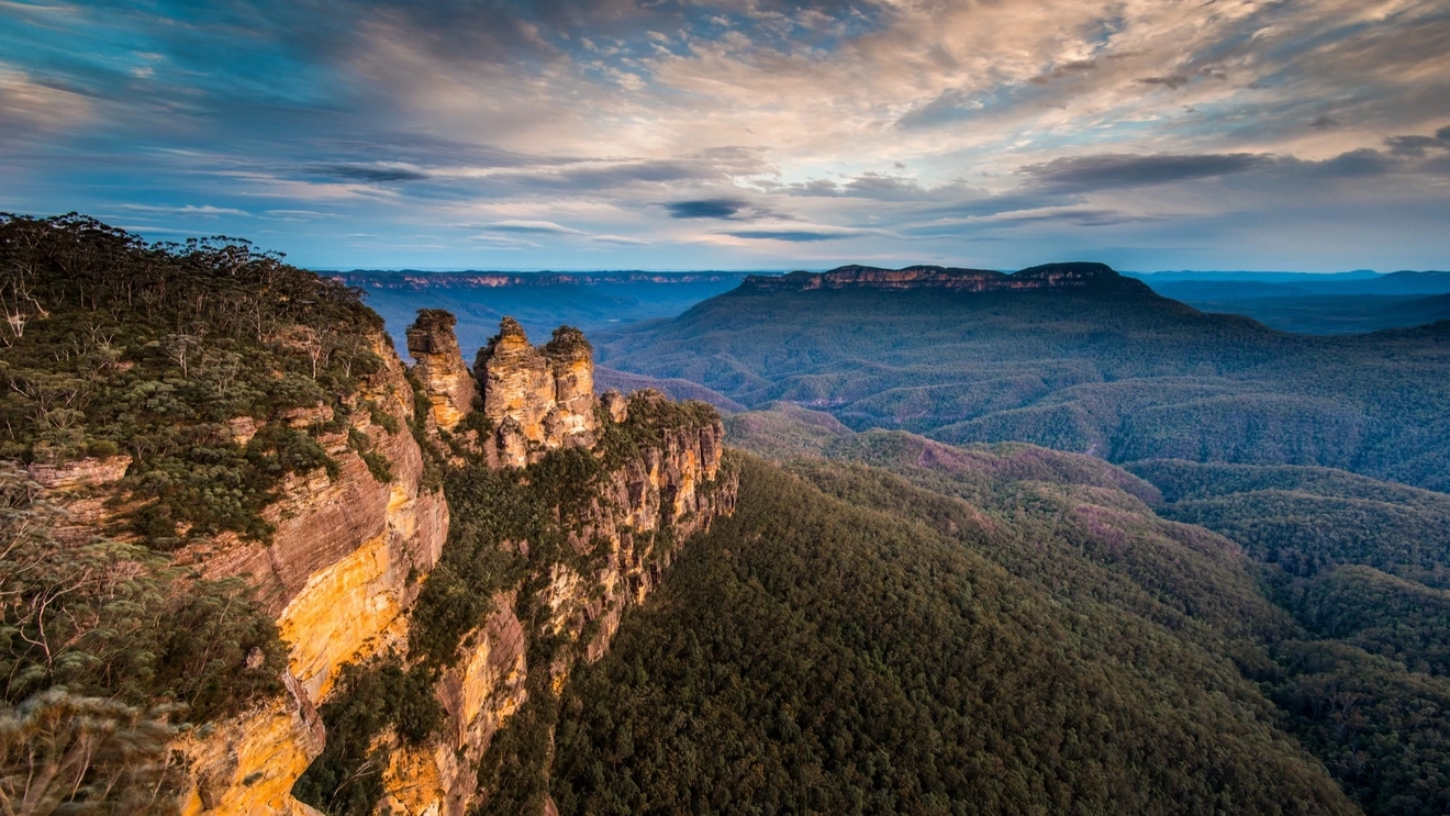 View of the Three Sisters in the foreground, from Echo Point Lookout, with eucalypt valleys and sandstone mountains in the background, Blue Mountains National Park.