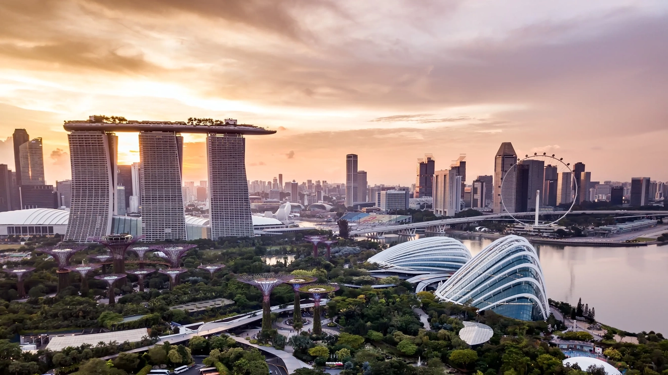 Aerial drone view of Singapore skyline at sunset, featuring the Marina Bay Sands and Gardens by the Bay. Image credit: stock.adobe.com