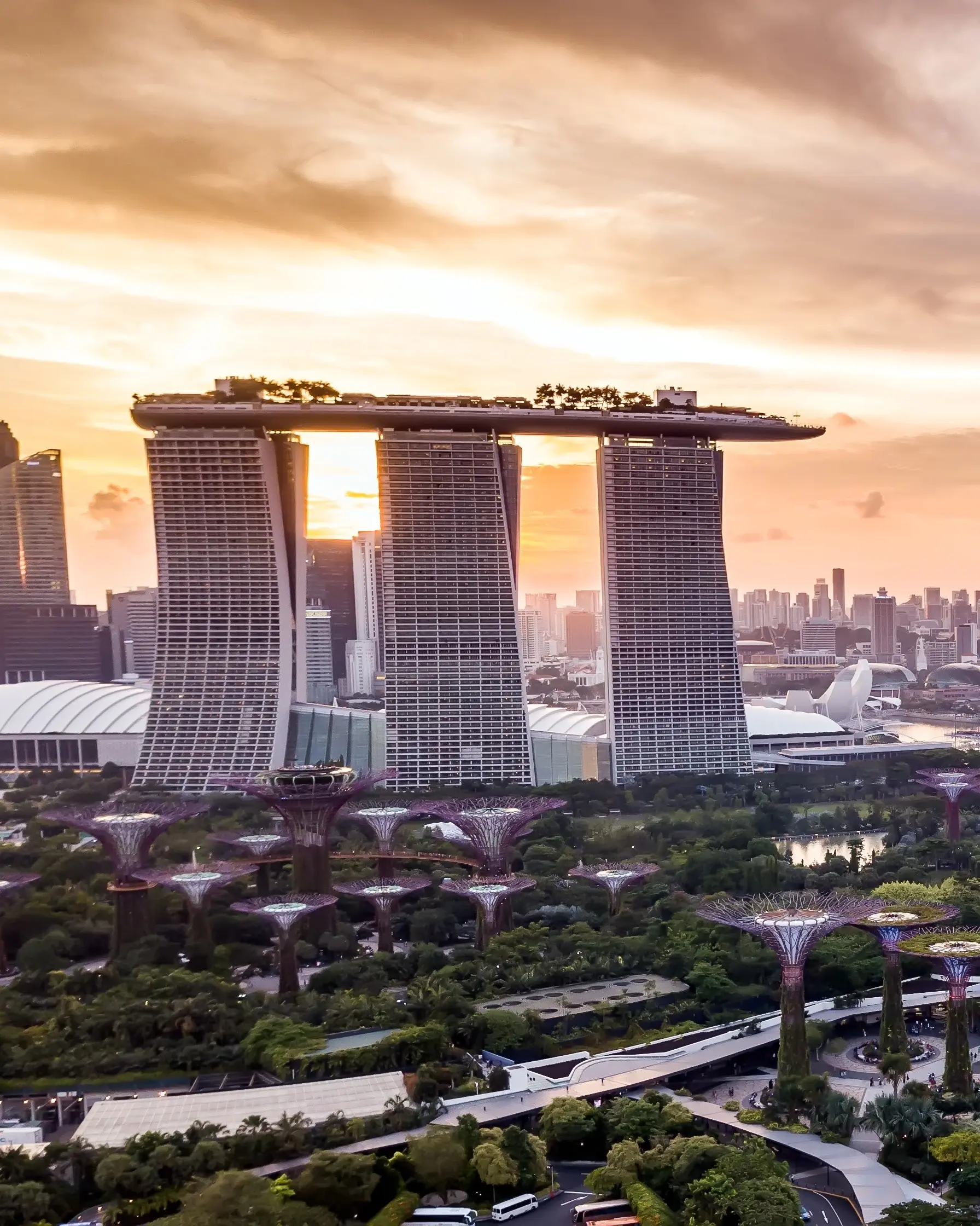 Aerial drone view of Singapore skyline at sunset, featuring the Marina Bay Sands and Gardens by the Bay. Image credit: stock.adobe.com