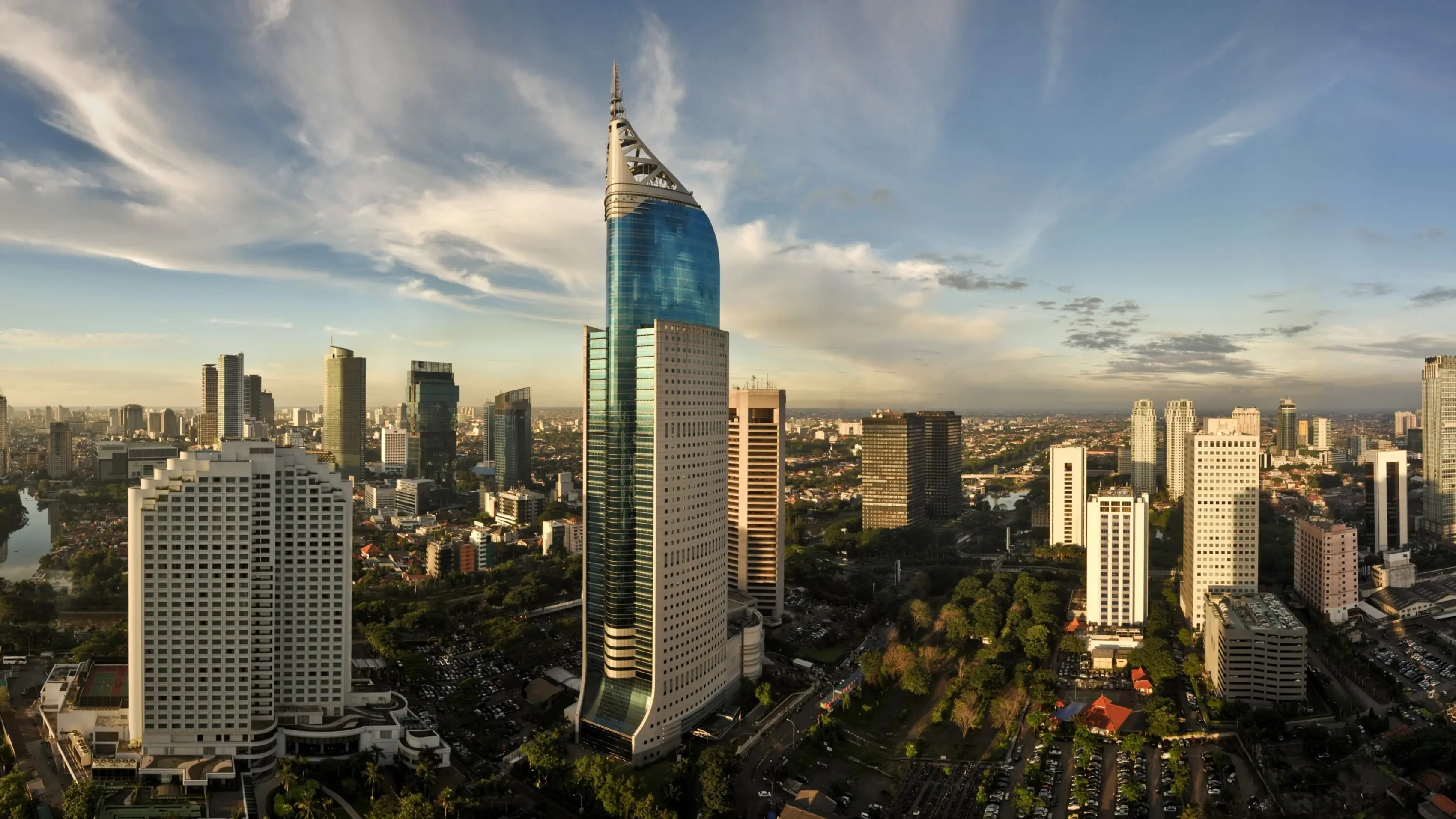 Jakarta city skyline with skyscrapers against a backdrop of blue sky and white clouds. Image credit: stock.adobe.com