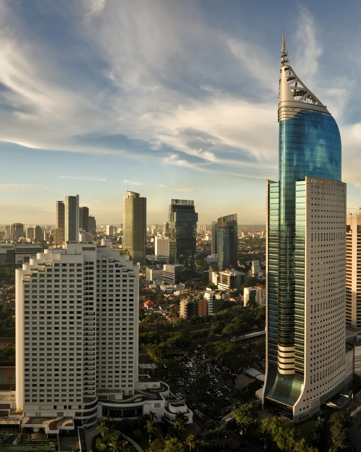 Jakarta city skyline with skyscrapers against a backdrop of blue sky and white clouds. Image credit: stock.adobe.com