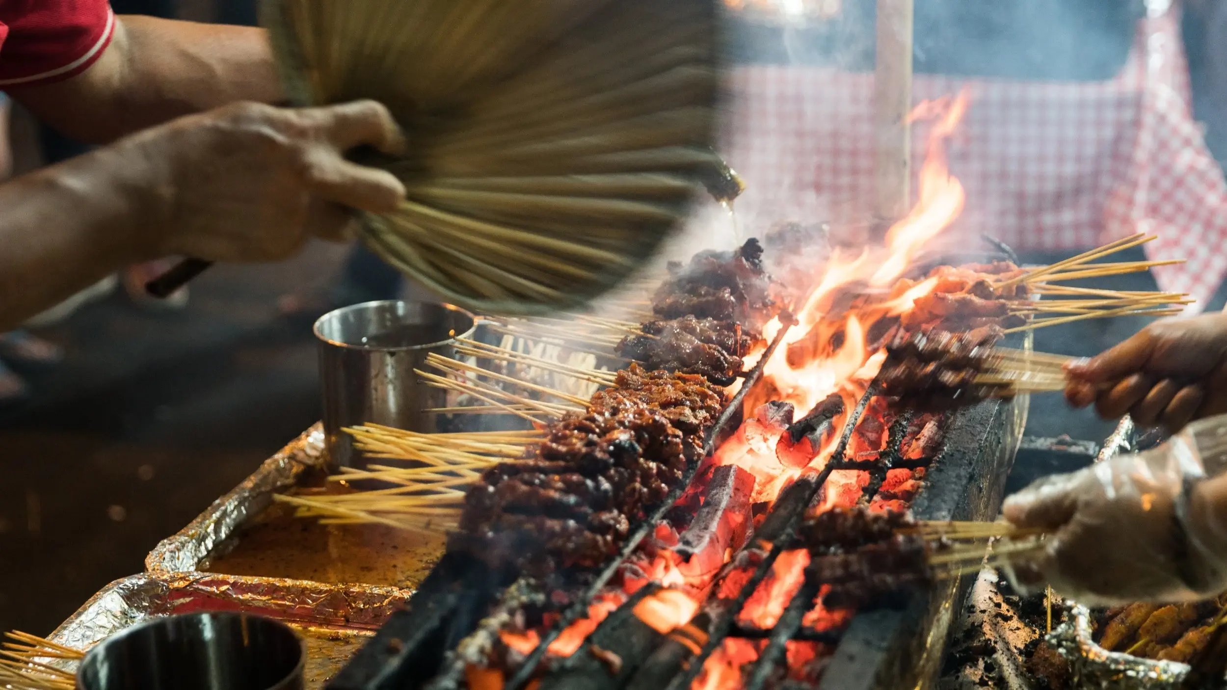 Meat skewers being cooked over hot coals at Singapore's Satay Street at Lau Pa Sat market. Image credit: stock.adobe.com