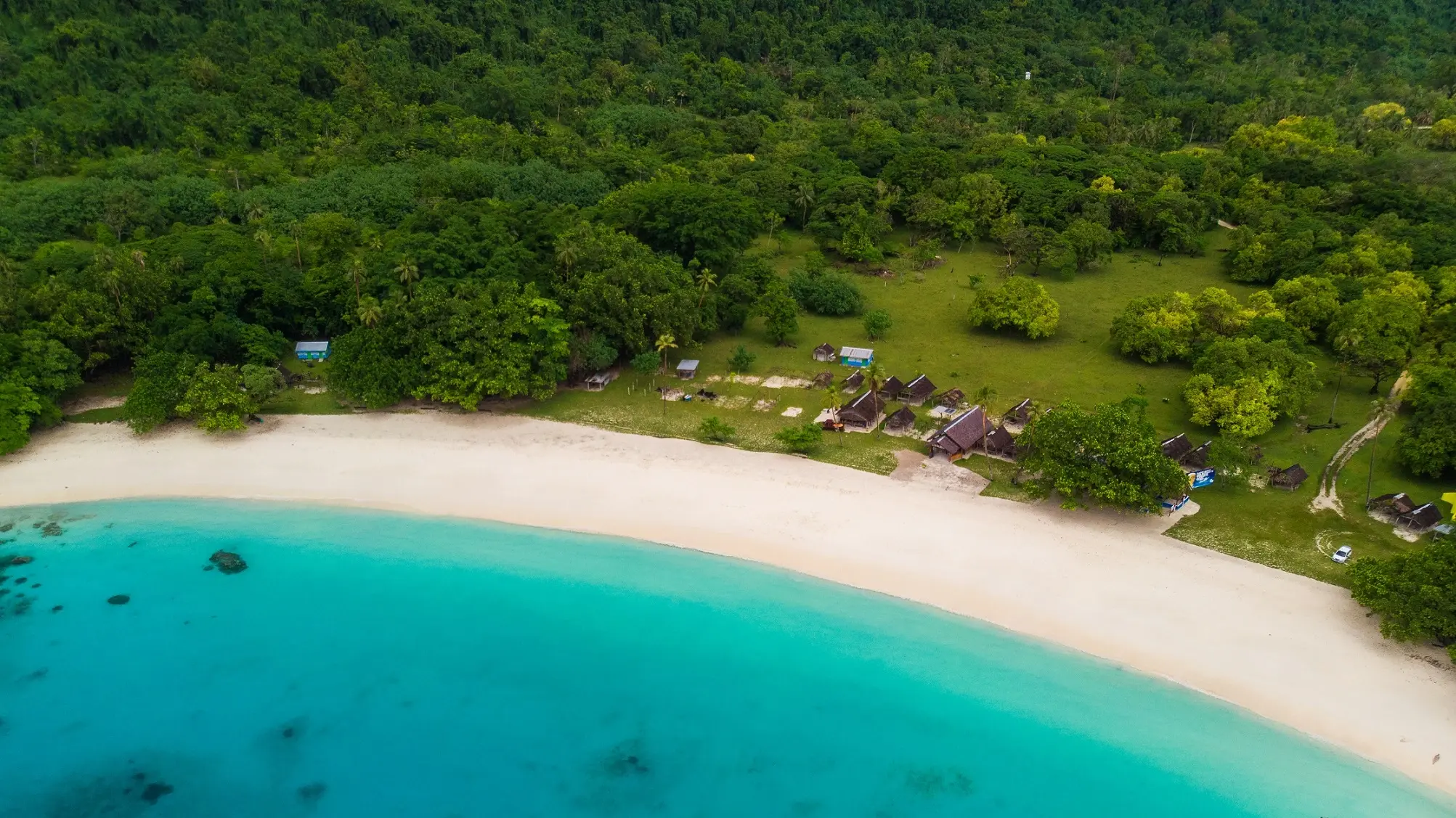 Aerial view of stunning Champagne Beach, all aquamarine water, white sand and lush vegetation. Espiritu Santo, Vanuatu. Image credit: stock.adobe.com