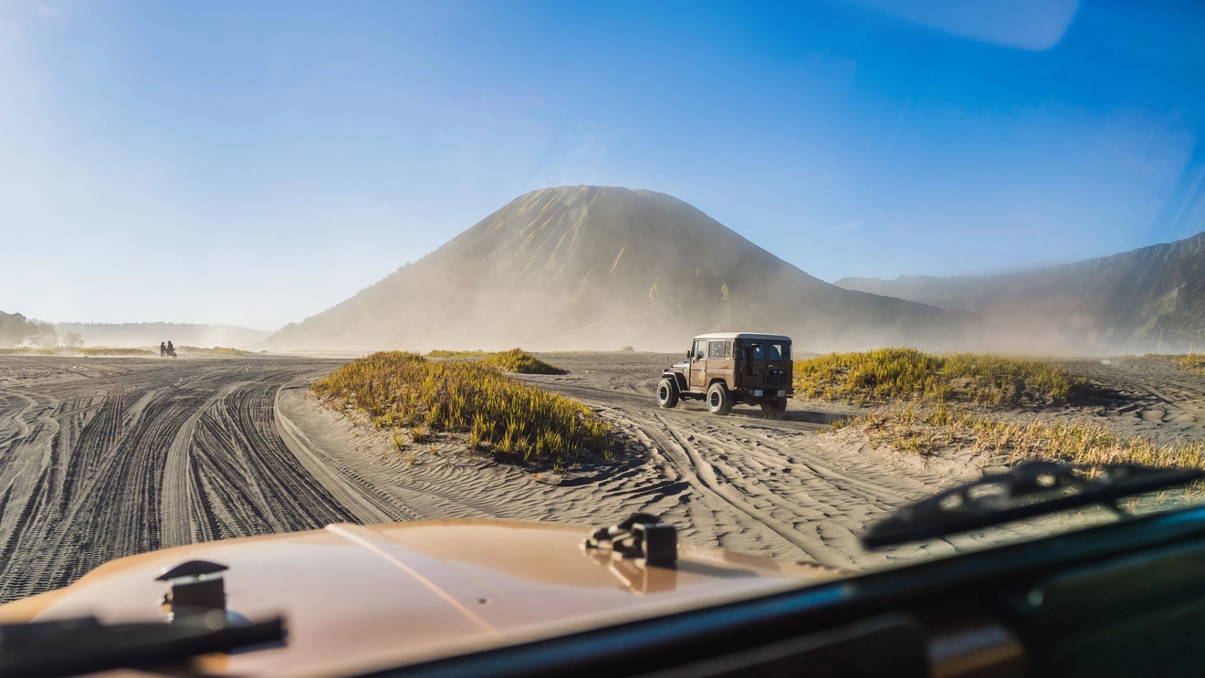 Jeeps crossing the desert plains in the Sea of Sands surrounding Mount Bromo, Surabaya, Indonesia. Image credit: stock.adobe.com