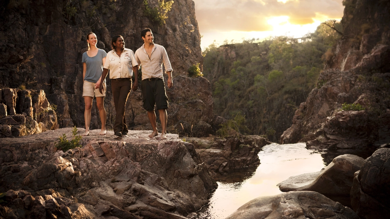 Aboriginal tour guide leading tourist couple through the beautiful Litchfield National Park. Image credit: Tourism NT/Shaana McNaught