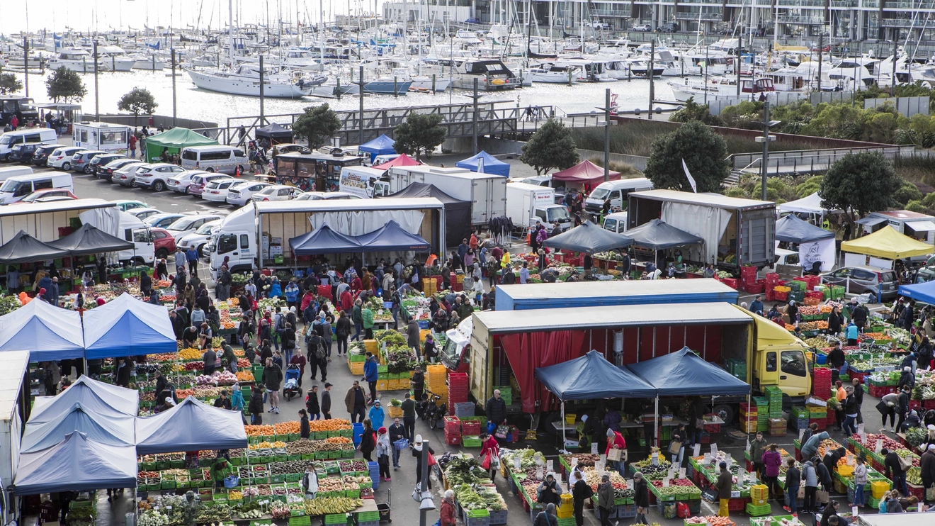 An aerial view of food stalls at Harbourside Market with Wellington Harbour in the background, Wellington, New Zealand. Image credit: Nicola Edmonds/WellingtonNZ