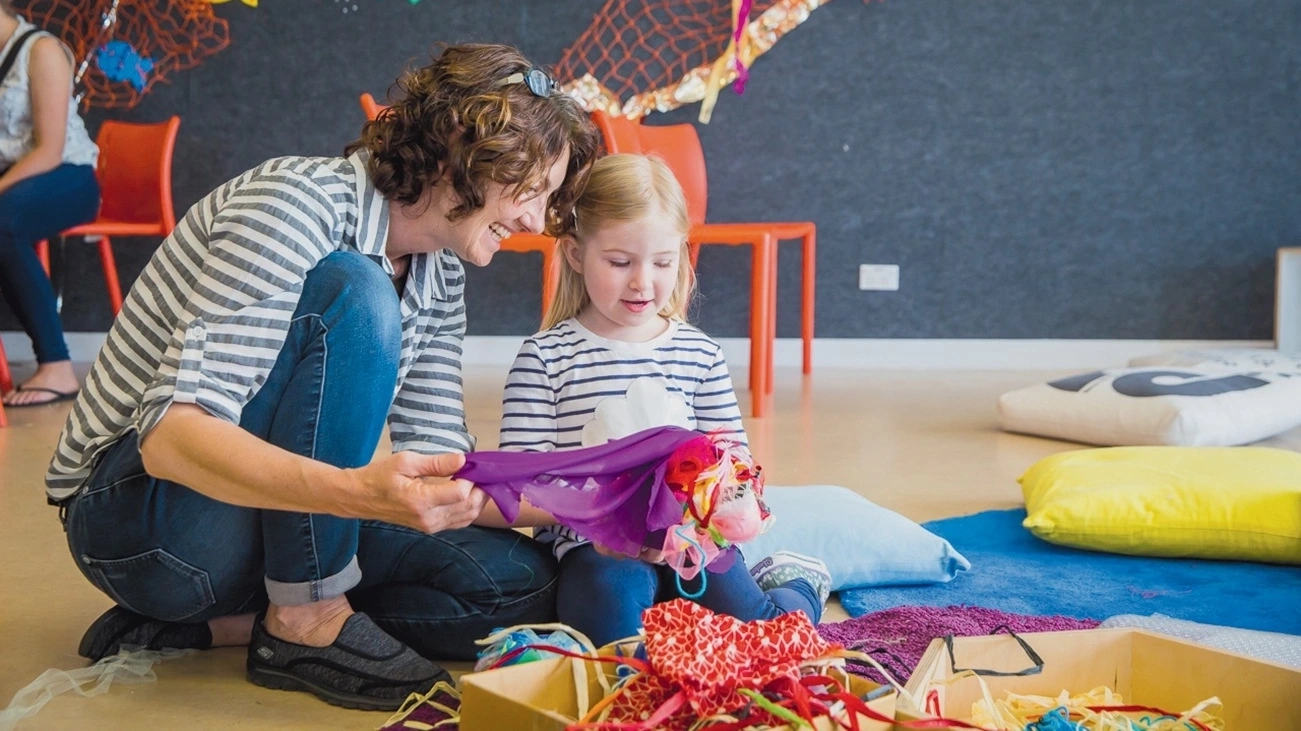 An adult and child play with a collection of material at the Museum of Contemporary Art Australia in Sydney.