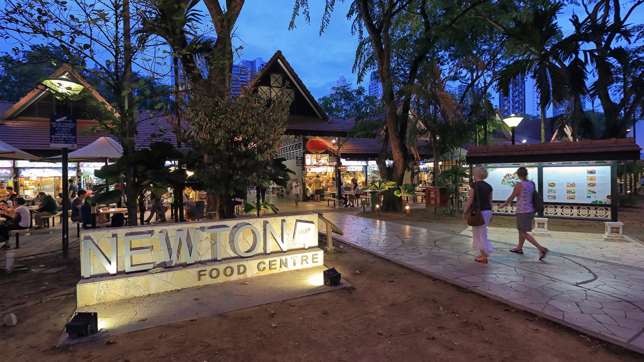 Exterior view of Singapore’s Newton Food Centre signage and entrance at night. Image credit: Singapore Tourism Board