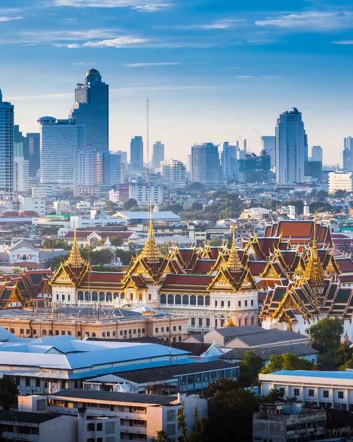 Bangkok’s Grand Palace in the foreground, city skyscrapers in the background, Bangkok, Thailand, at sunrise. Image credit: stock.adobe.com