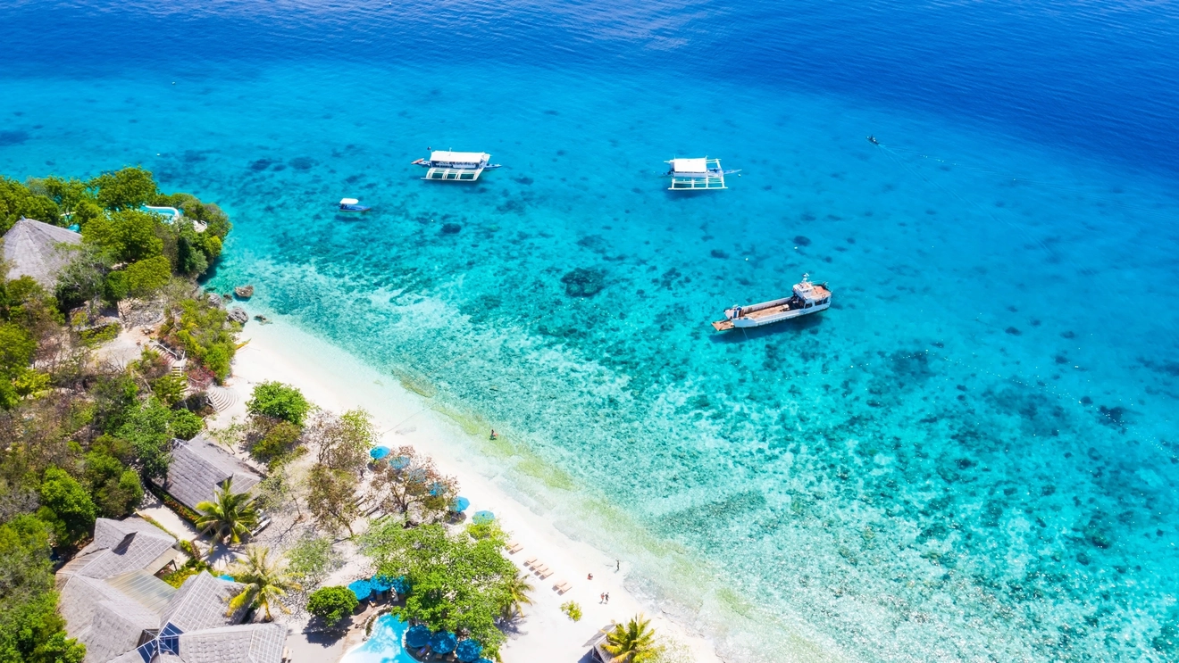 Aerial view of the heavenly aquamarine water and white sand of Oslob beach, Sumilon Island, Cebu. Image credit: stock.adobe.com