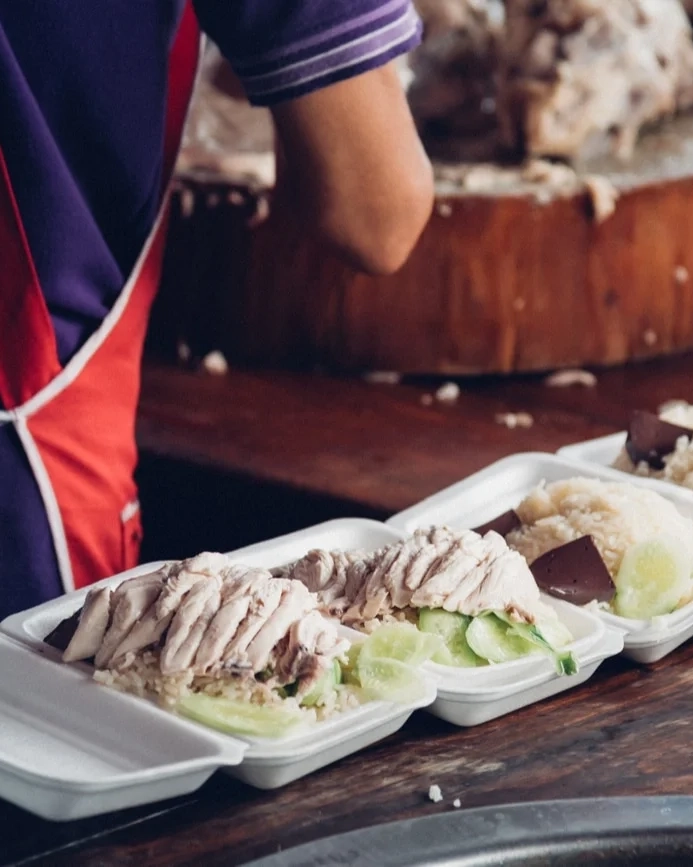 Hainanese chicken rice being prepared on a bench