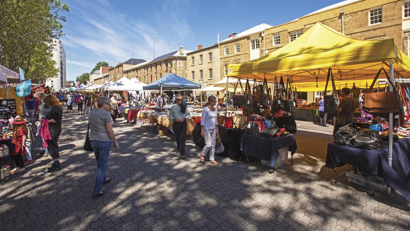 People browsing outdoor stalls at Hobart’s Salamanca Market. Image credit: Tourism Australia/Graham Freeman