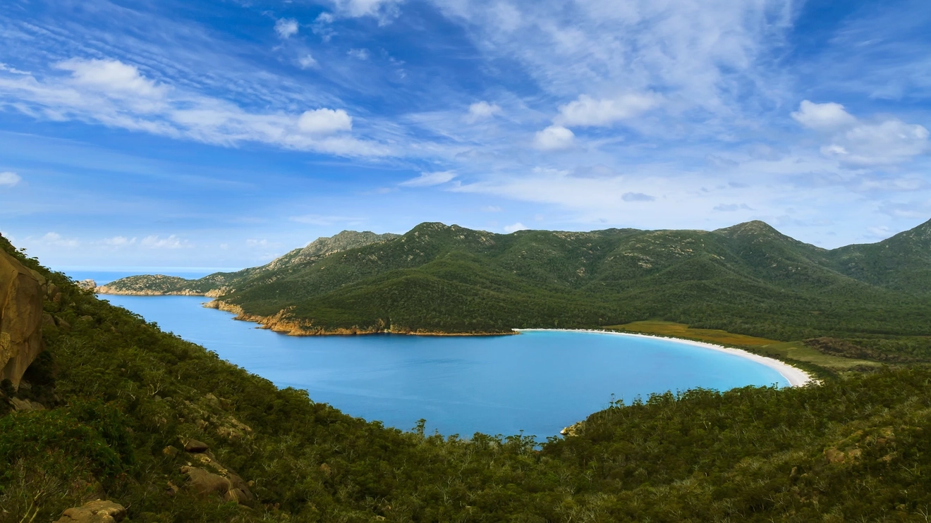 Aerial view of beach, water and mountains at Wineglass Bay.