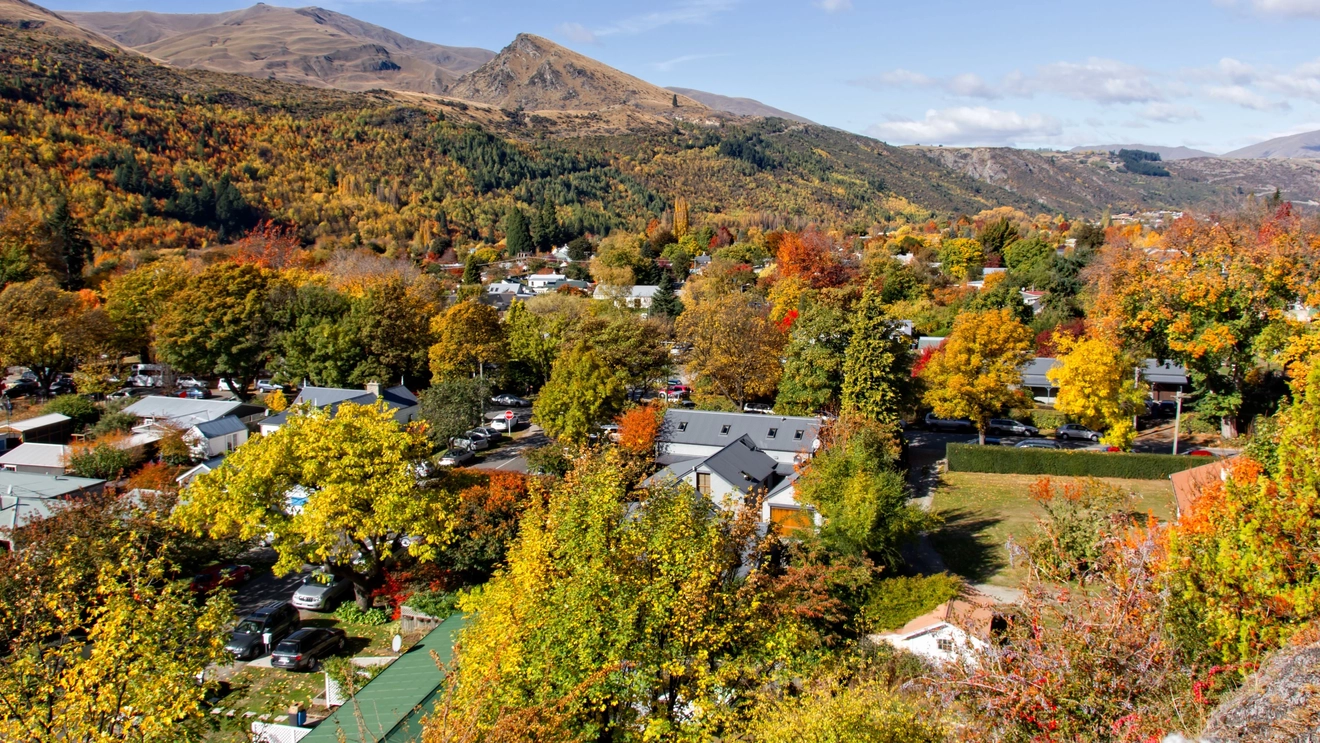 Aerial view of Arrowtown and autumnal foliage in surrounding hills, New Zealand.