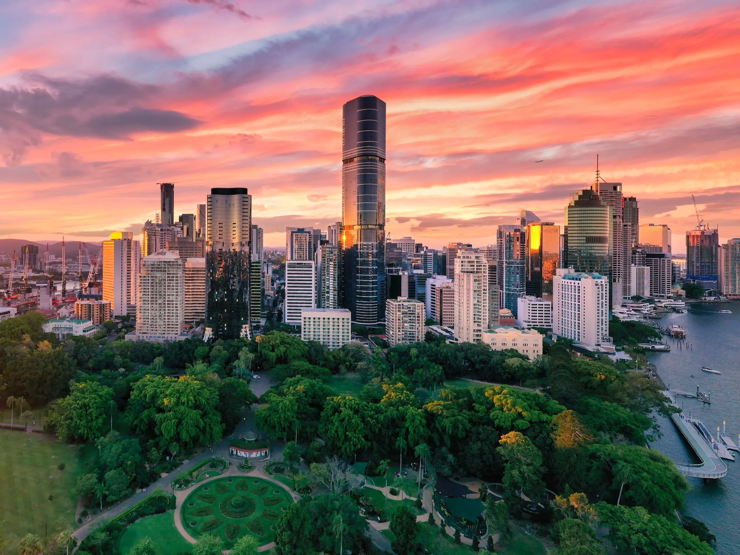Aerial view of Botanic Gardens, Brisbane River and Brisbane CBD skyline at sunset. Image credit: Tourism and Events Queensland