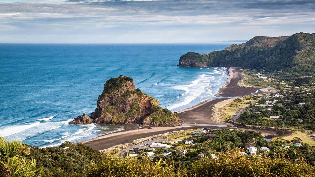 Aerial view of black-sand Piha Beach and Lion Rock, near Auckland, New Zealand. Image credit: adobe.stock.com