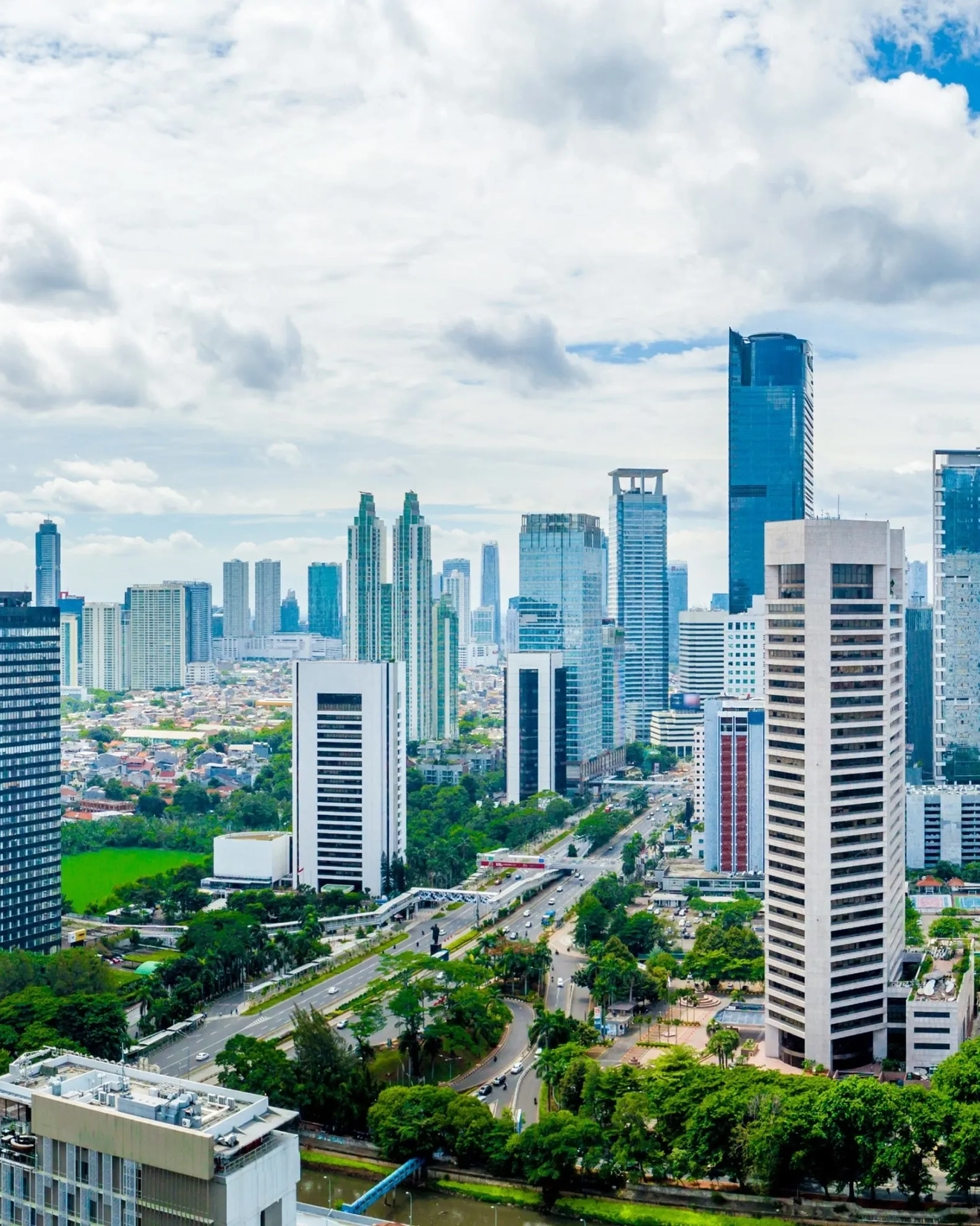 A panoramic view of downtown Jakarta’s skyline with high-rises against a backdrop of blue sky and white clouds. Image credit: stock.adobe.com