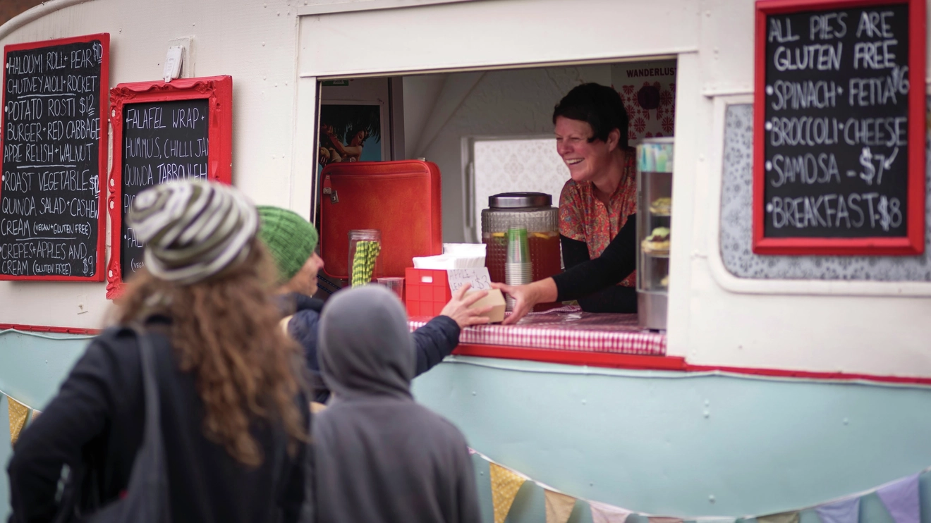 Stallholder chats with customers from her bakery caravan at Harvest Market, Launceston, Tasmania. Image credit: Tourism Tasmania/Rob Burnett