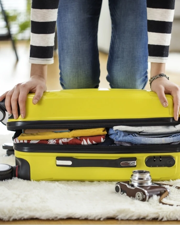 A person packs a suitcase