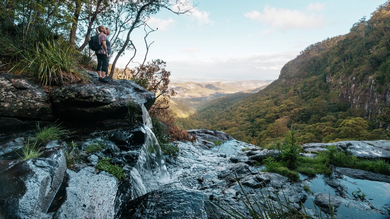 A bushwalker at the top of Morans Falls overlooking Morans Creek Gorge, Lamington National Park. Image credit: Tourism and Events Queensland.